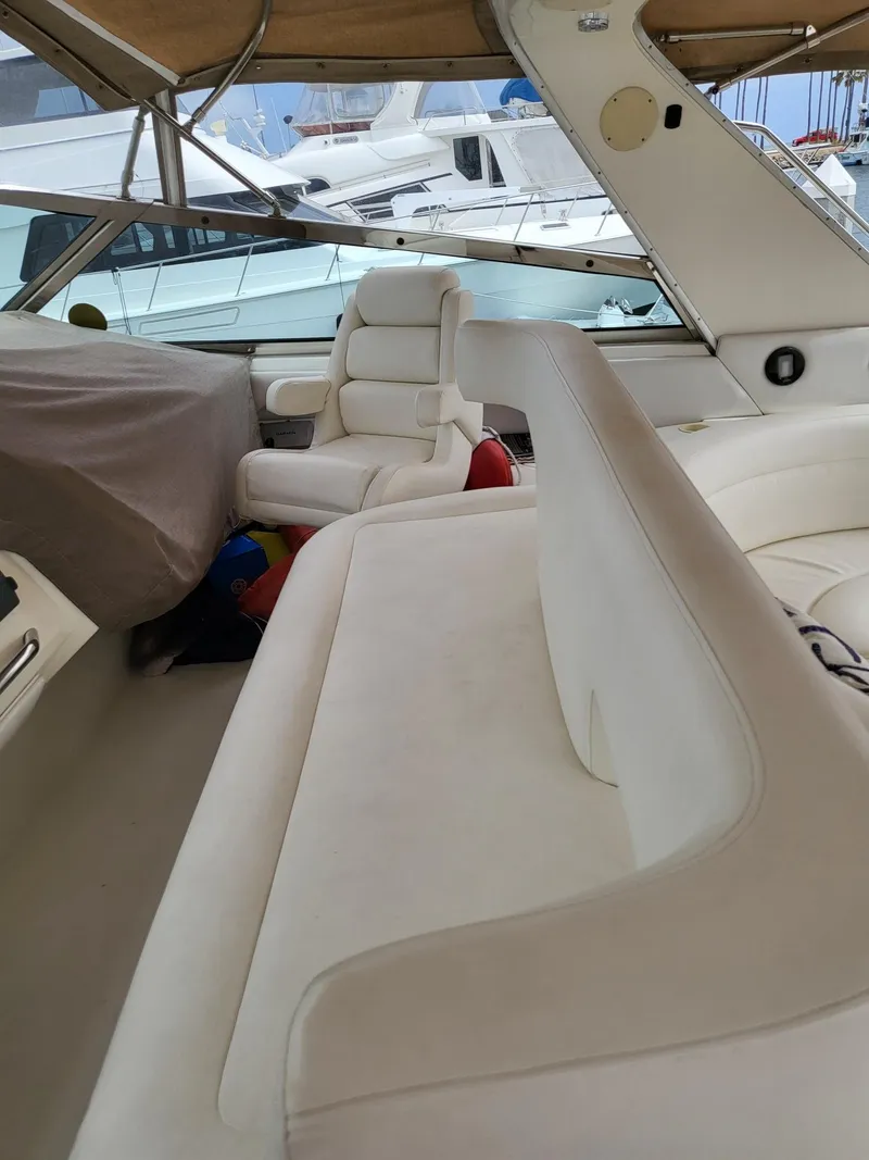 Slide: The Image of 1996 Sea Ray 500 Sundancer interior with white seating and covered dashboard. - 28