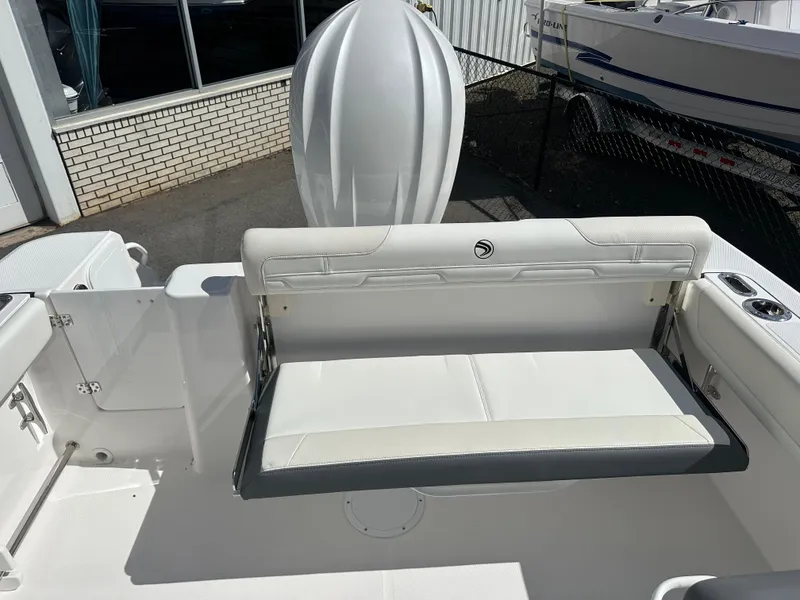 Slide: The Image of 2025 Edgewater 248CX Crossover boat interior with outboard motor, docked near a building. - 10