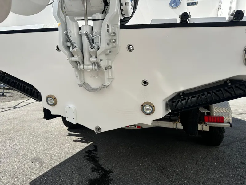 Slide: The Image of 2025 Edgewater 248CX Crossover boat, rear view, parked outdoors on a sunny day. - 6