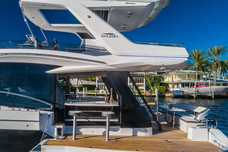 Slide: The Image of 2023 Galeon 500 Fly yacht docked, showcasing modern design and spacious deck. - 11