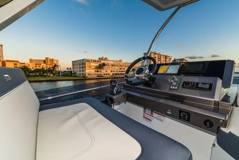 Slide: The Image of Helm station of 2023 Galeon 500 Fly yacht with cityscape in the background. - 16