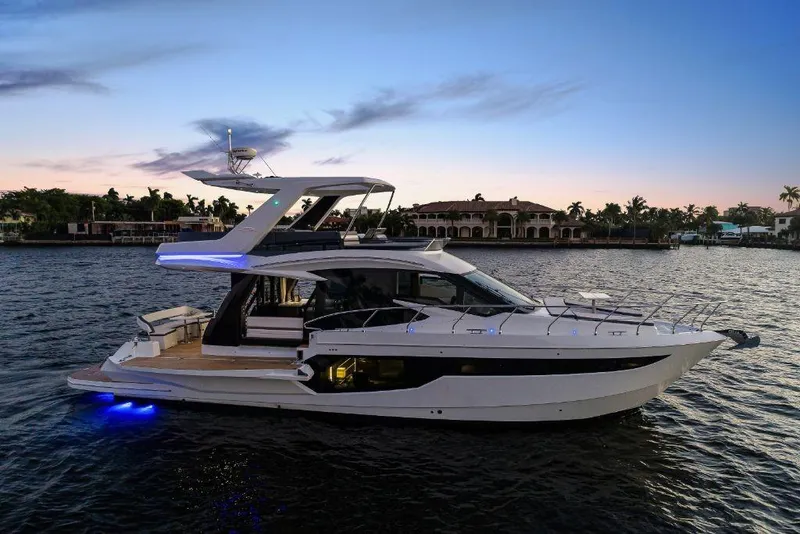 Slide: The Image of 2023 Galeon 500 Fly yacht at sunset on a serene waterway. - 5