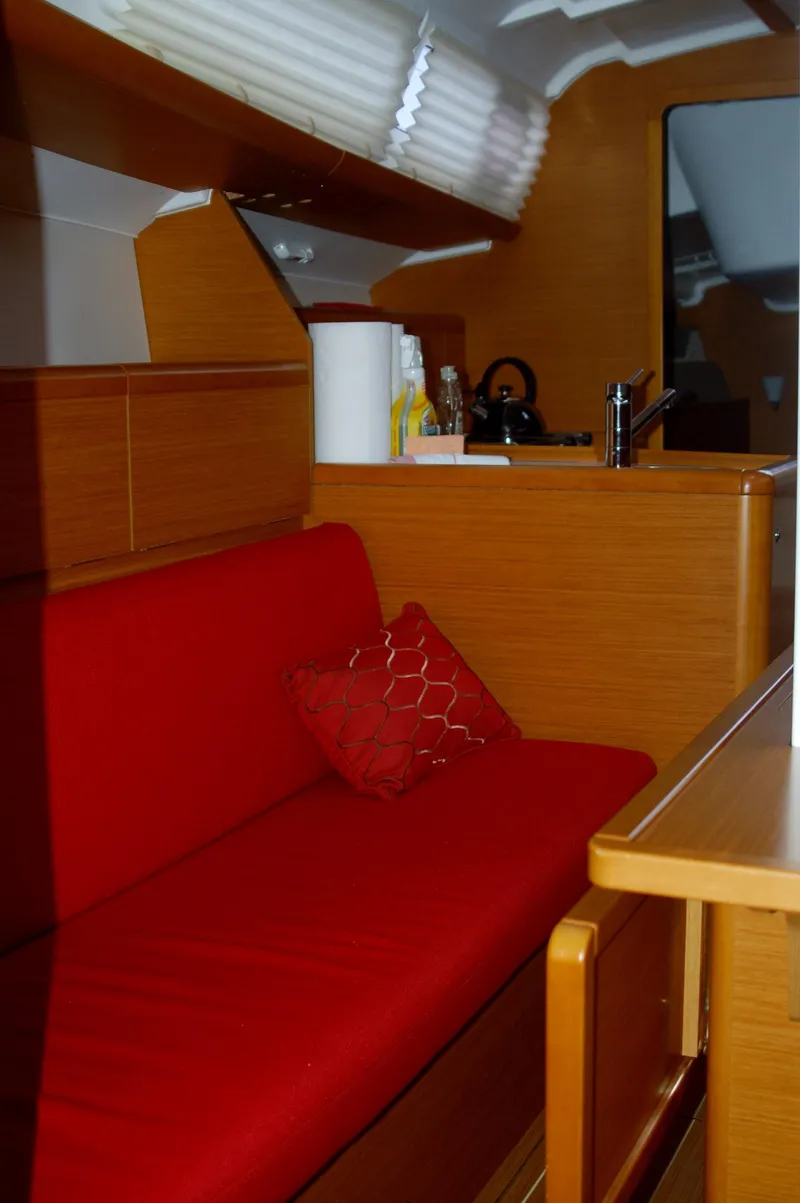 Slide: The Image of Interior of 2013 Jeanneau Sun Odyssey 33i with red seating and wooden finish. - 23