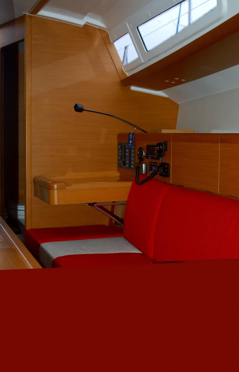 Slide: The Image of Interior of 2013 Jeanneau Sun Odyssey 33i sailboat with red seating and navigation equipment. - 24