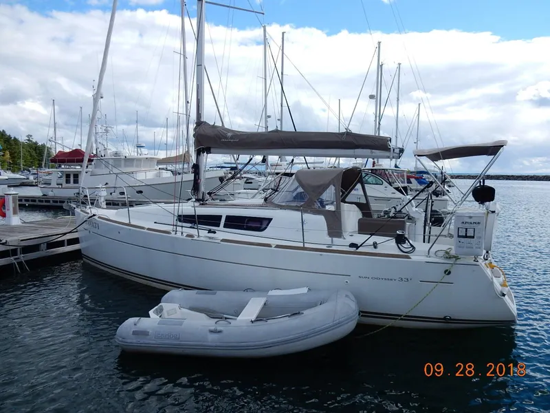 Slide: The Image of 2013 Jeanneau Sun Odyssey 33i sailboat docked with inflatable dinghy nearby. - 6