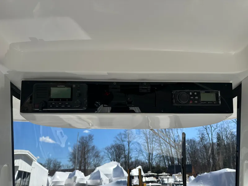Slide: The Image of 2025 Edgewater 262 Center Console dashboard with electronic controls, set against a snowy outdoor backdrop. - 27
