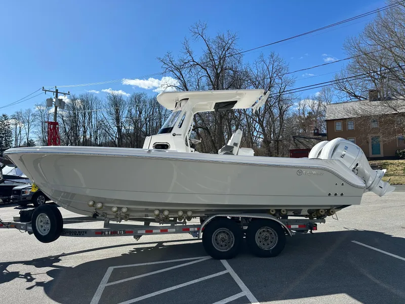 Slide: The Image of 2025 Edgewater 262 Center Console boat on trailer, parked outdoors under clear sky. - 5