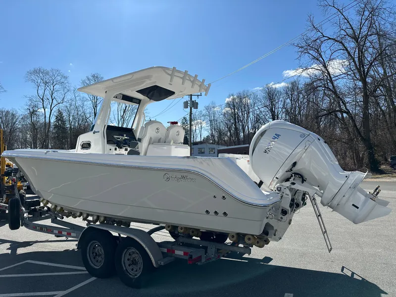 Slide: The Image of 2025 Edgewater 262 Center Console boat on trailer, parked outdoors under clear sky. - 6