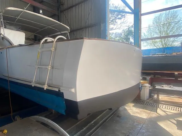 Slide: The Image of 1953 Rybovich Express boat in a shed, showcasing its stern and ladder. - 21