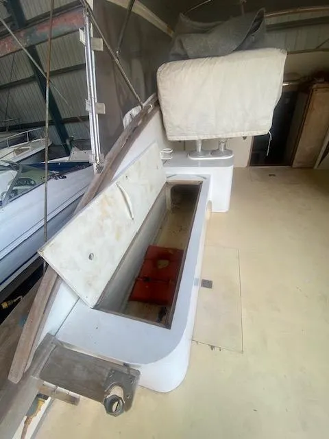 Slide: The Image of 1953 Rybovich Express boat interior with open storage compartment in a docked setting. - 31