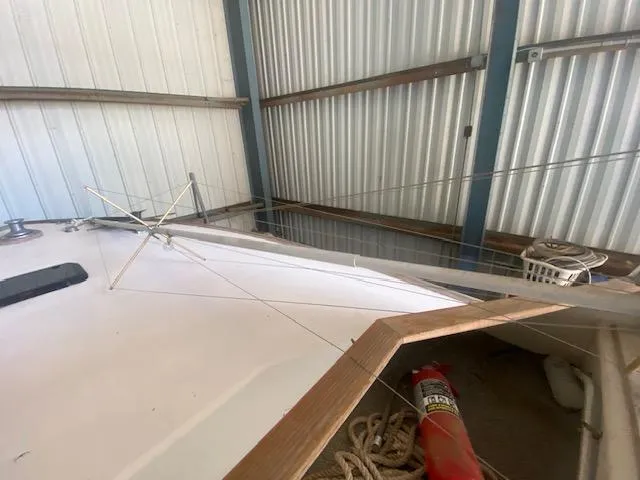 Slide: The Image of 1953 Rybovich Express boat in storage, featuring deck and safety equipment. - 38