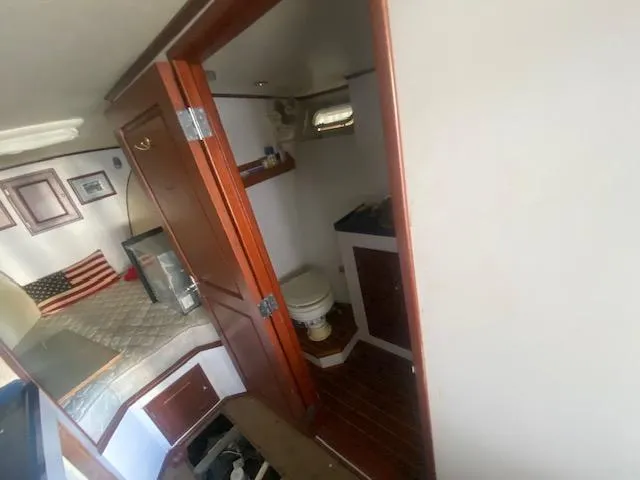 Slide: The Image of Interior of a 1953 Rybovich Express boat featuring a cozy cabin and bathroom. - 41