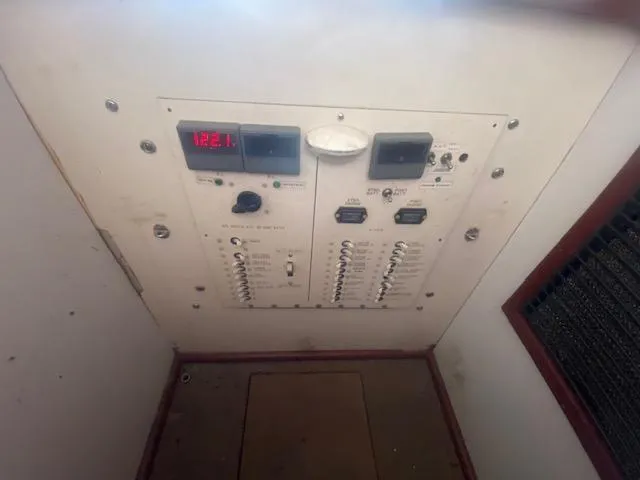 Slide: The Image of Electrical panel of a 1953 Rybovich Express boat, featuring various switches and a digital display. - 48