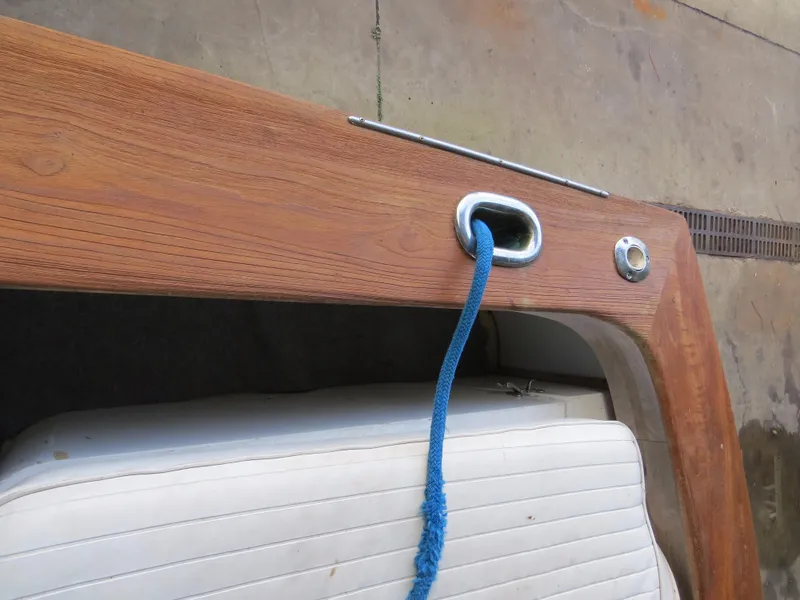 Slide: The Image of 1953 Rybovich Express boat detail with blue rope and wooden finish. - 7