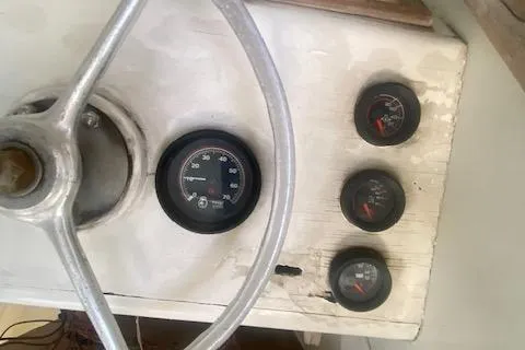 Slide: The Image of A classic 1953 boat with a simple dashboard and a large steering wheel. - 57
