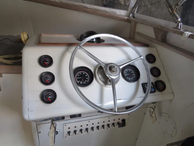 Slide: The Image of 1953 Rybovich Express boat dashboard with steering wheel and gauges. - 8