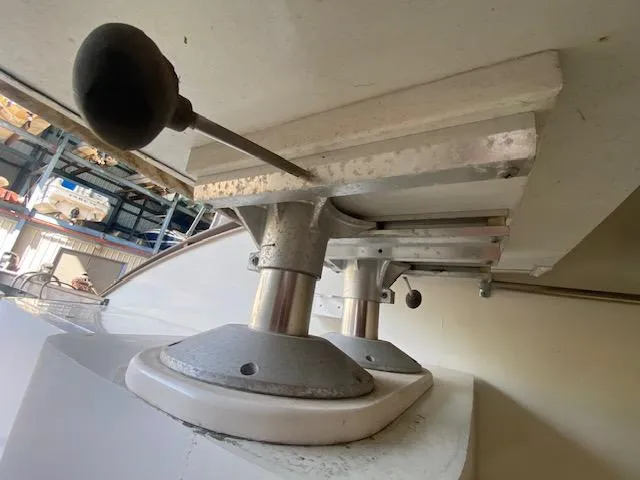 Slide: The Image of Close-up of a boat's steering wheel and control mechanism, likely in a workshop or shipyard. - 52