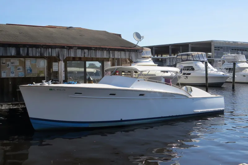 The Image of 1953 Rybovich Express boat docked at a marina, surrounded by other vessels. - 1