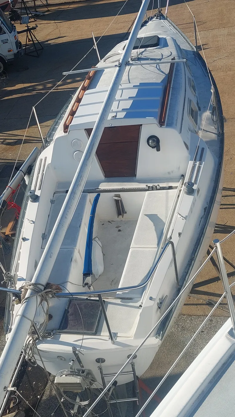 Slide: The Image of 1982 Hunter 25 sailboat on dry dock, viewed from above, showcasing deck and mast. - 20