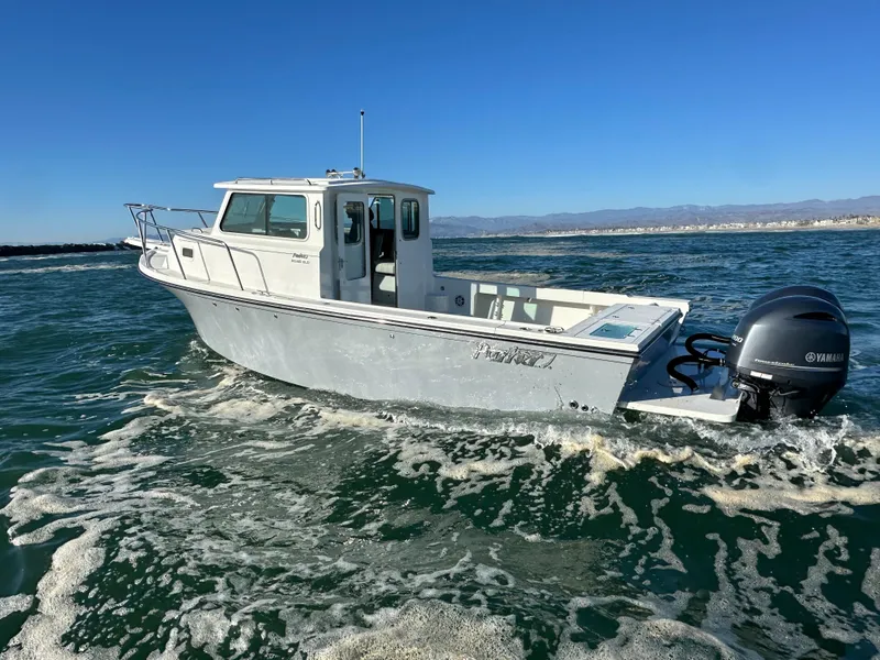 Slide: The Image of 2023 Parker 2520 XLD Sport Cabin boat cruising on open water. - 0