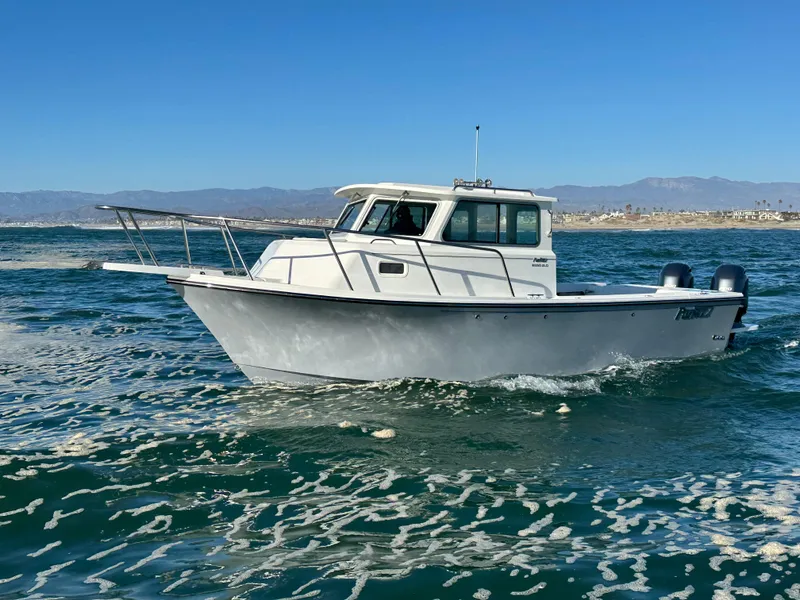 Slide: The Image of 2023 Parker 2520 XLD Sport Cabin boat cruising on open water. - 1
