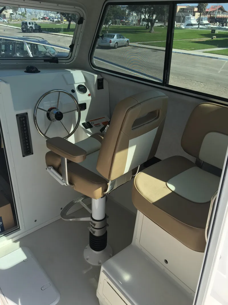 Slide: The Image of Interior of 2023 Parker 2520 XLD Sport Cabin boat with helm and seating. - 2