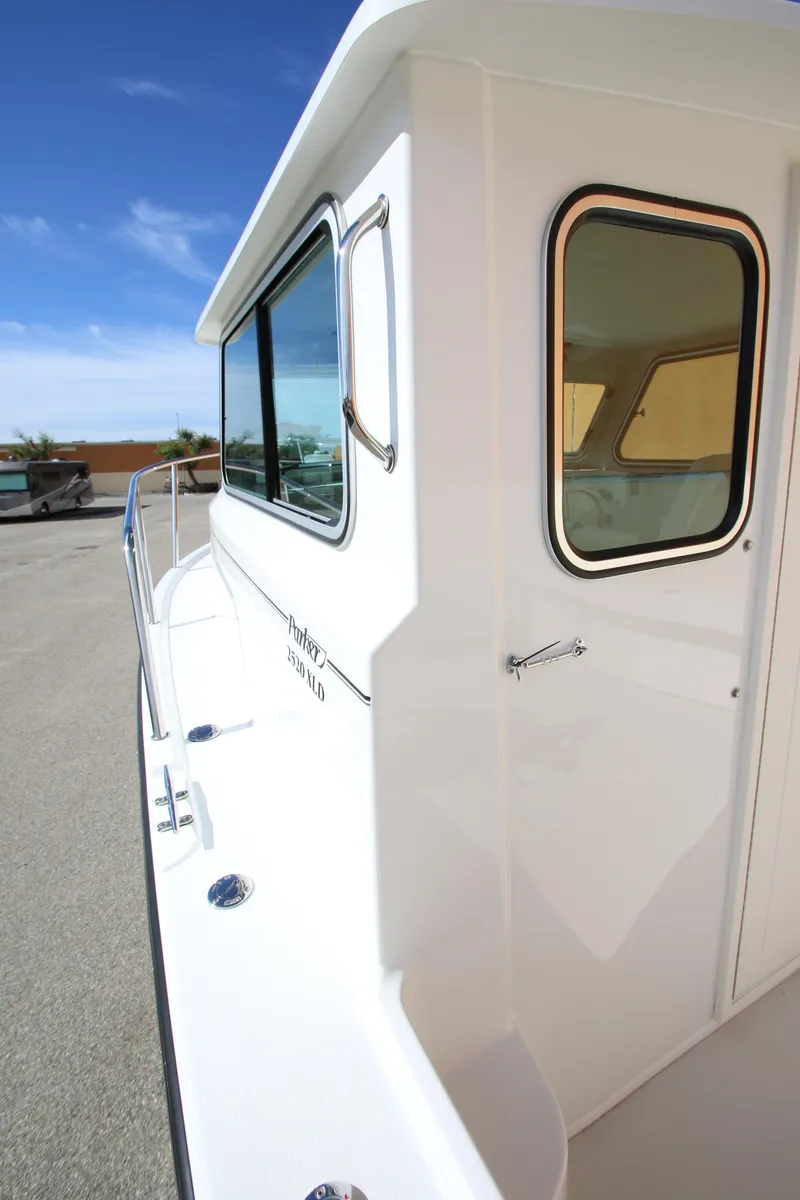 Slide: The Image of 2023 Parker 2520 XLD Sport Cabin boat exterior with windows and door. - 6