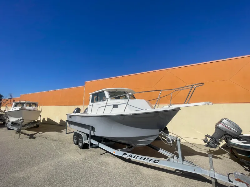 Slide: The Image of 2023 Parker 2520 XLD Sport Cabin boat on trailer against orange wall. - 8