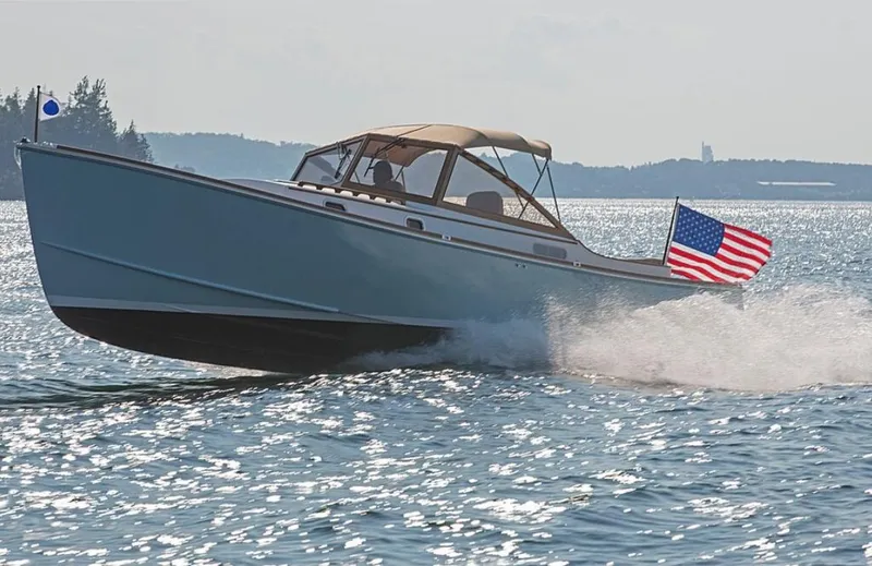 Slide: The Image of 2026 CH Marine Shelter Island Runabout cruising on a sunny day with American flag. - 2