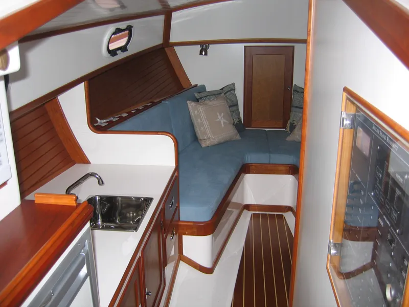Slide: The Image of 2026 CH Marine Shelter Island Runabout interior with cozy seating and compact kitchenette. - 3