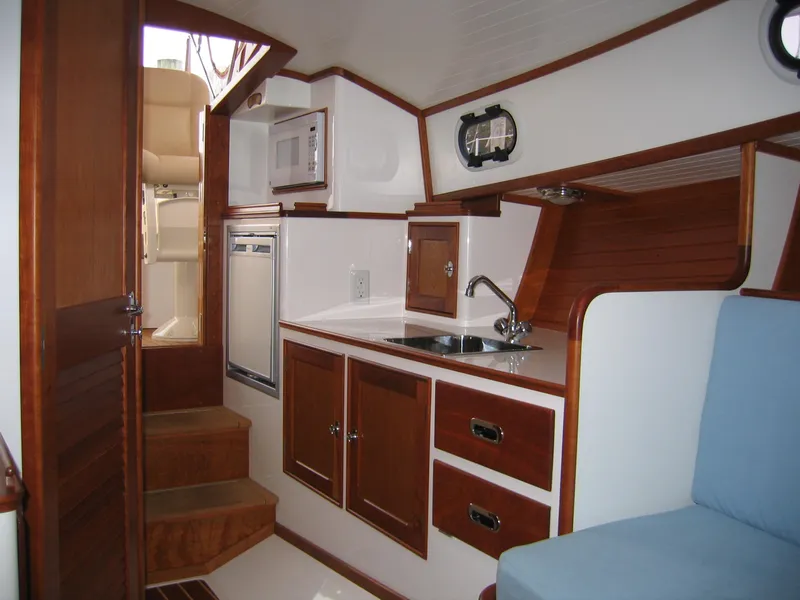 Slide: The Image of Interior of 2026 CH Marine Shelter Island Runabout with kitchenette and wooden cabinetry. - 4
