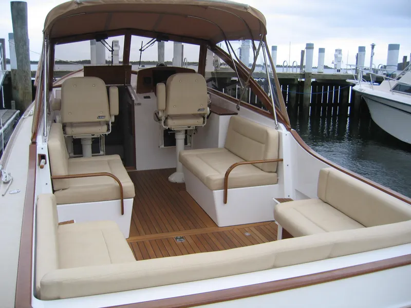 Slide: The Image of 2026 CH Marine Shelter Island Runabout with spacious seating and elegant design at a marina. - 8