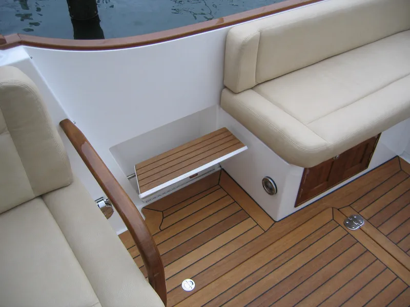Slide: The Image of 2026 CH Marine Shelter Island Runabout interior with beige seating and wooden flooring. - 9