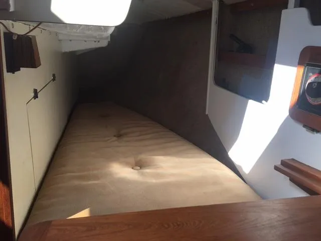 Slide: The Image of 1985 S2 9.1 sailboat interior cabin with cushioned berth and wooden accents. - 10