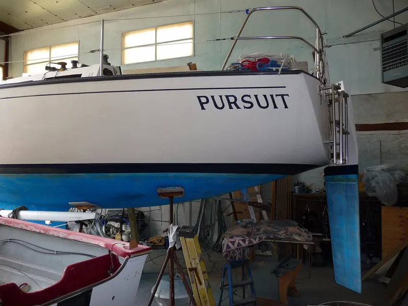 Slide: The Image of 1985 S2 9.1 sailboat Pursuit in a workshop, undergoing maintenance. - 17