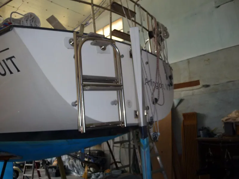 Slide: The Image of Sailboat S2 9.1 (1985) in a workshop, showing stern ladder and Arlington name. - 23