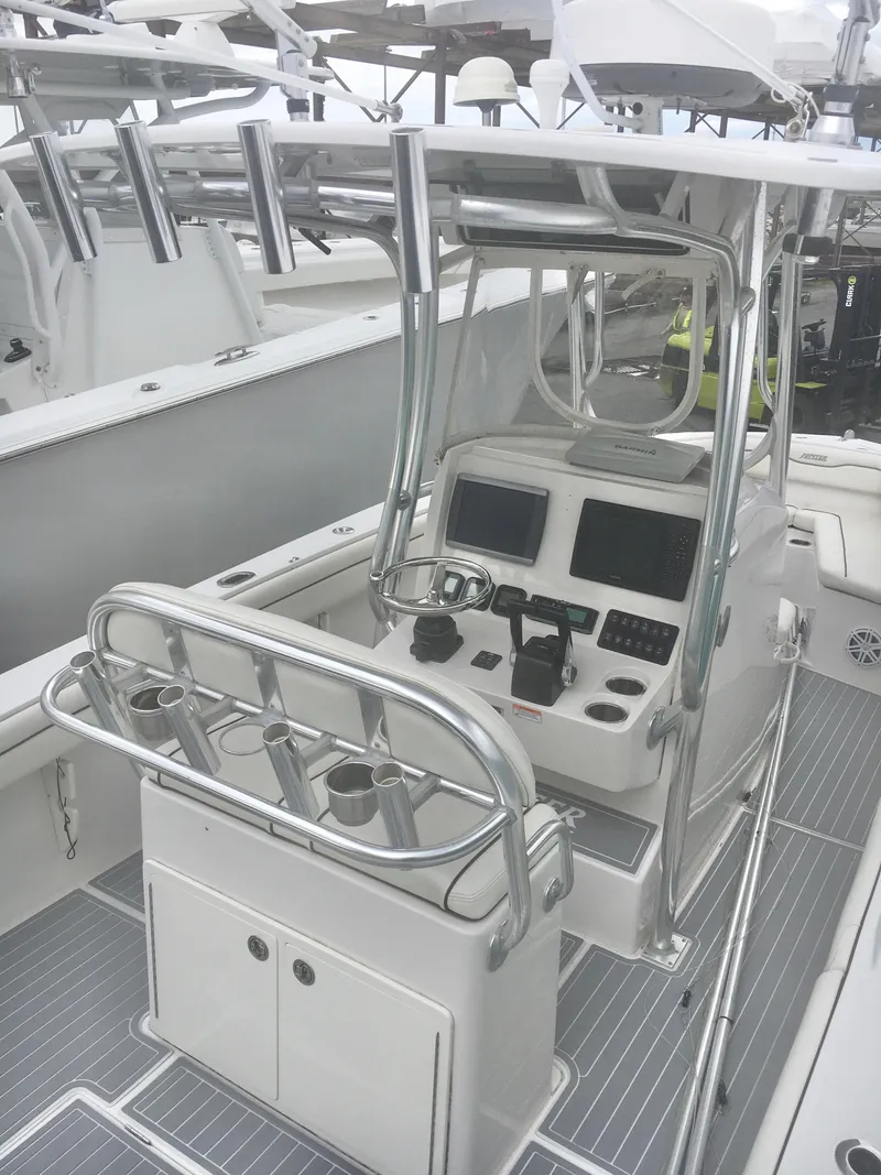 Slide: The Image of 2012 Jupiter 26 Forward Seating boat with center console and T-top, docked under cloudy skies. - 6