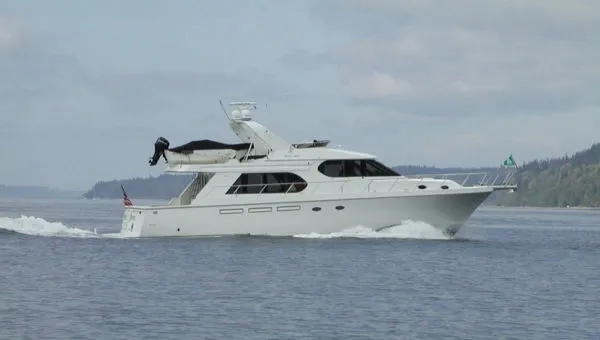 The Image of 1998 Ocean Alexander Pilothouse Model 584 yacht cruising on calm waters. - 0