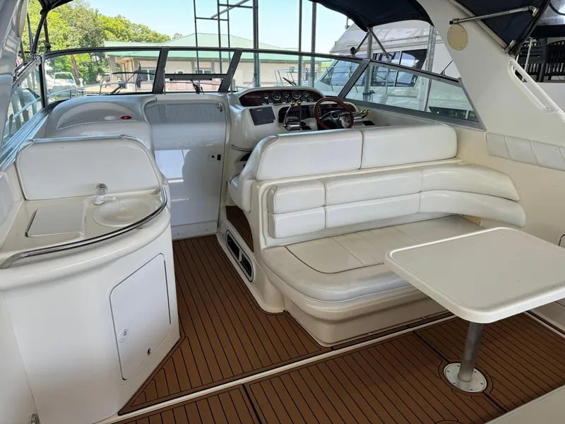 Slide: The Image of 1998 Sea Ray 330 Sundancer boat interior with white seating and wooden flooring. - 12