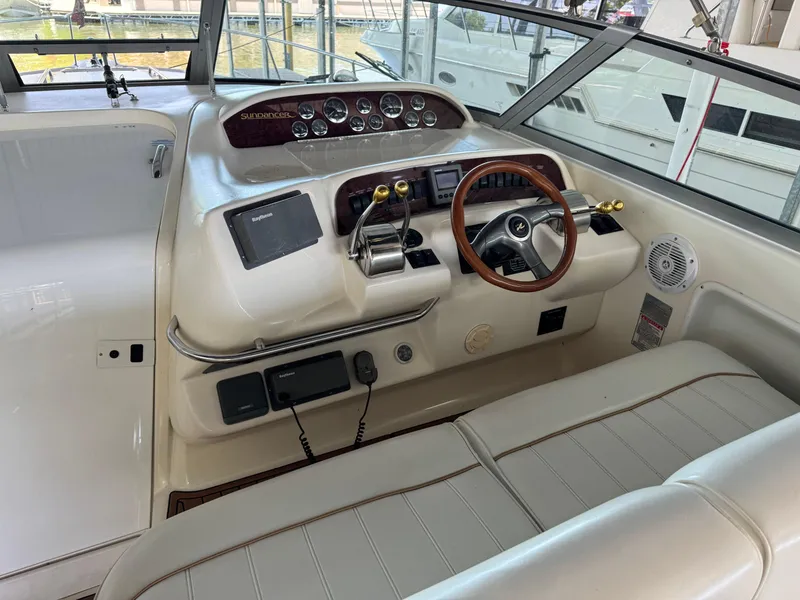 Slide: The Image of 1998 Sea Ray 330 Sundancer helm with wood steering wheel and modern navigation equipment. - 14