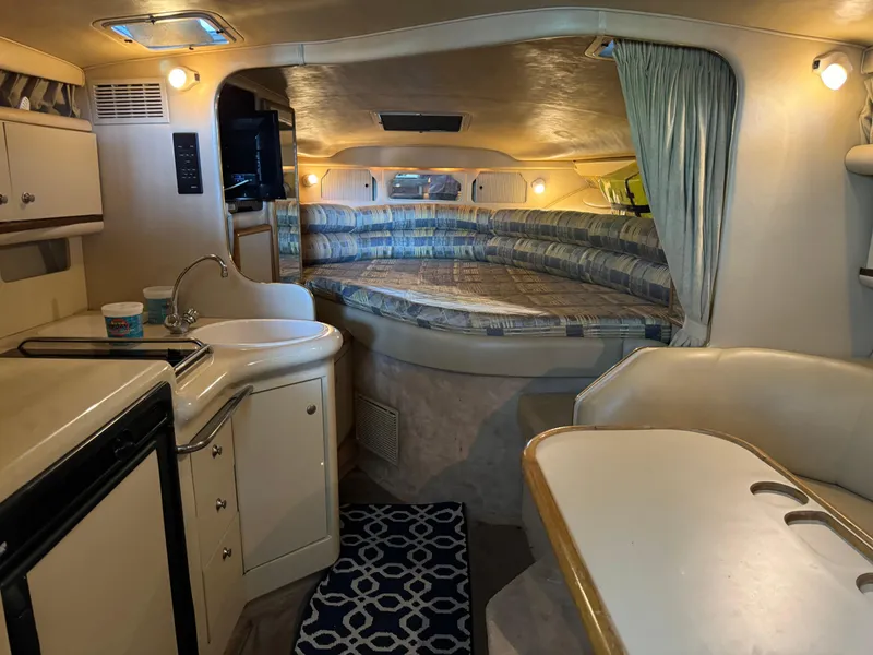 Slide: The Image of Interior of 1998 Sea Ray 330 Sundancer yacht with kitchenette, seating area, and bed. - 17
