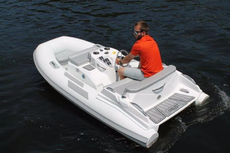 Slide: The Image of 2018 Ribjet 10 Jet Yacht Tender on water with driver in orange shirt. - 3