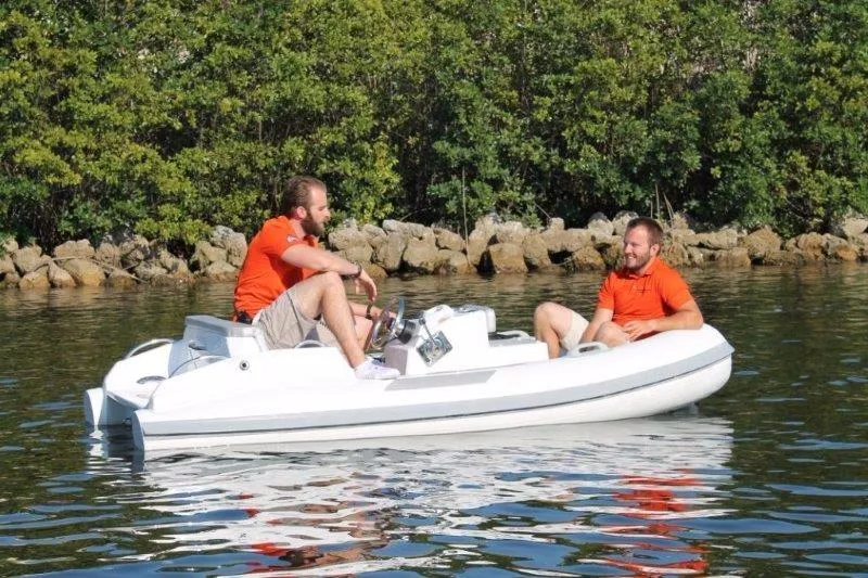 Slide: The Image of 2018 Ribjet 10 Jet Yacht Tender with two men in orange shirts on calm water. - 4