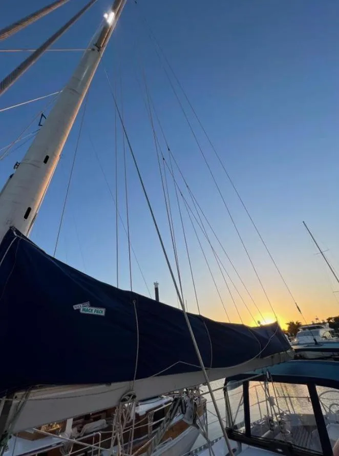 Slide: The Image of 1985 Gib'Sea 126 sailboat at sunset, docked with mast and rigging visible. - 11