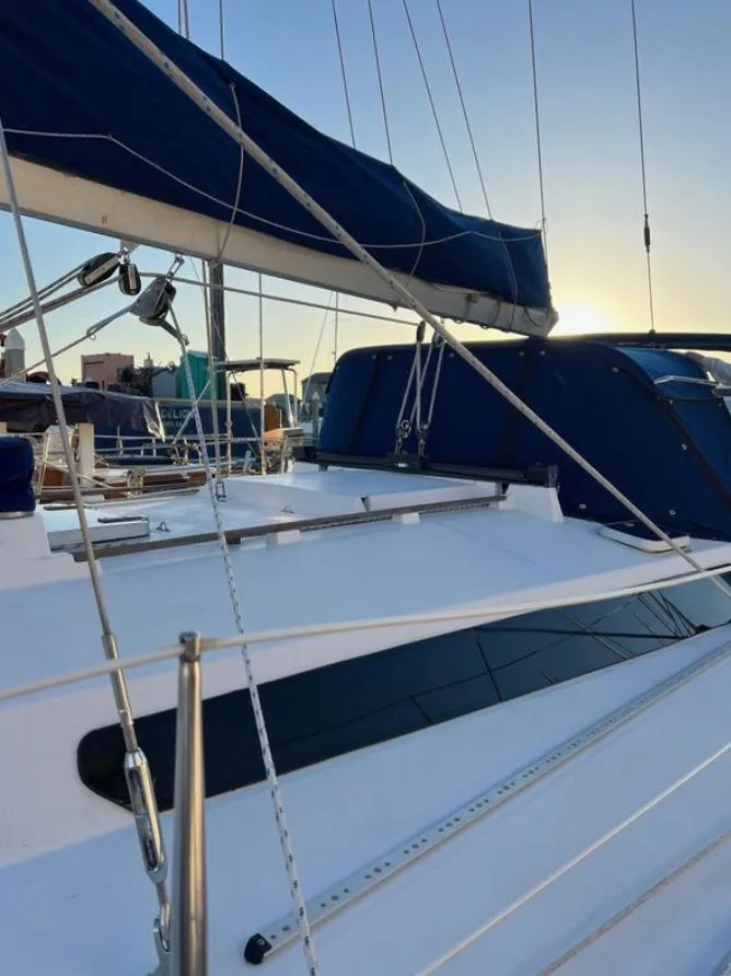 Slide: The Image of Sailing yacht Gib'Sea 126, 1985 model, with blue sails at sunset in a marina. - 14