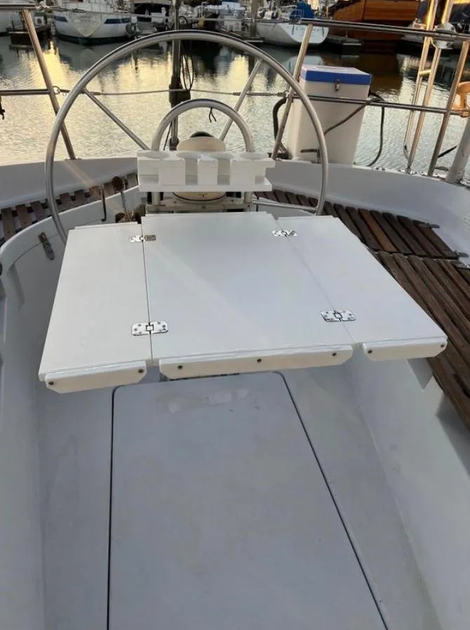 Slide: The Image of Cockpit of 1985 Gib'Sea 126 sailboat with steering wheel and foldable table. - 23