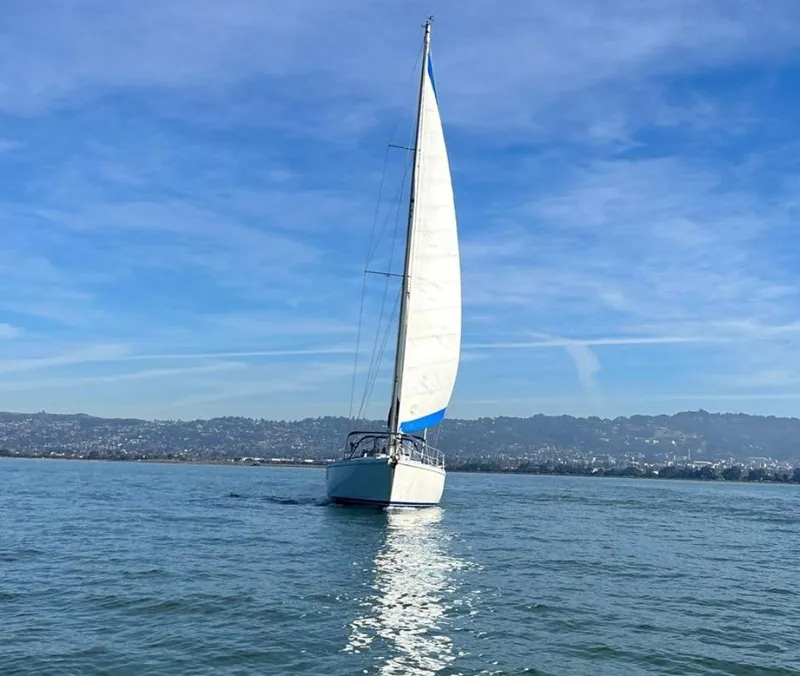 Slide: The Image of Sailboat Gib'Sea 126 (1985) gliding on calm waters under a clear blue sky. - 3