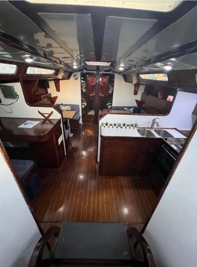 Slide: The Image of Interior of 1985 Gib'Sea 126 sailboat with wooden flooring and compact kitchen area. - 35