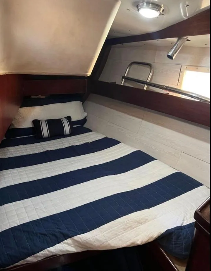 Slide: The Image of Cozy cabin interior of 1985 Gib'Sea 126 sailboat with striped bedding. - 43