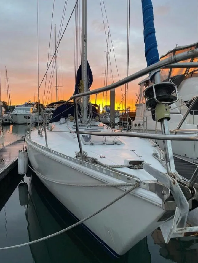 Slide: The Image of 1985 Gib'Sea 126 sailboat docked at sunset, reflecting on calm water. - 5